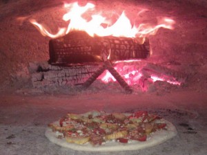 pizza patate salsiccia fresca piccante_infase di cottura-forno a legna